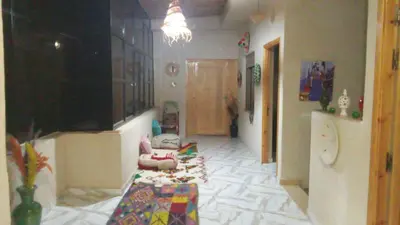 a hallway with a room with a couch and a table at charmante villa à découvrir in Aghmat