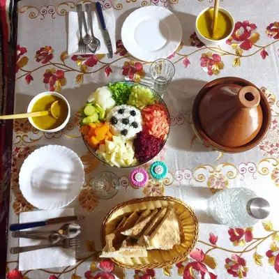 a table with plates and a bowl of food on it at Gîte Jamal taghia in Taghia