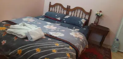 a bed with a blue comforter with towels on it at Stay 5 minutes from Fes airport in Oulad Tayeb