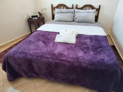 a purple blanket on a bed in a room at Stay 5 minutes from Fes airport in Oulad Tayeb