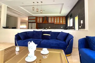 a living room with a blue couch and a table at luxury villa ourika in Oulad Akkou