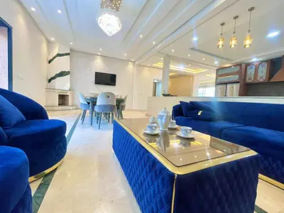 a living room with blue couches and a table at luxury villa ourika in Oulad Akkou