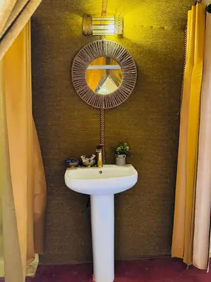 a bathroom with a white sink and a mirror at Sunlight Luxury Desert Camp in Merzouga