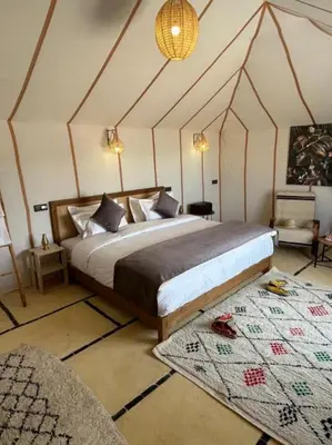 a bedroom with a large bed in a tent at Sunlight Luxury Desert Camp in Merzouga
