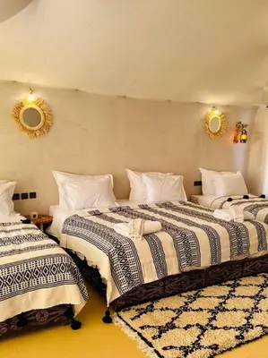 two beds in a room with two mirrors on the wall at Sunlight Luxury Desert Camp in Merzouga