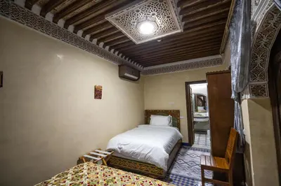 a bedroom with a bed and a chair in a room at Saphiryad in Fès