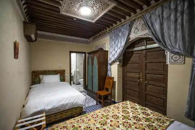 a bedroom with two beds and a window and a door at Saphiryad in Fès