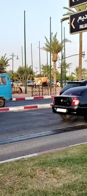 two cars driving down a road with a street sign at JMEL B&b