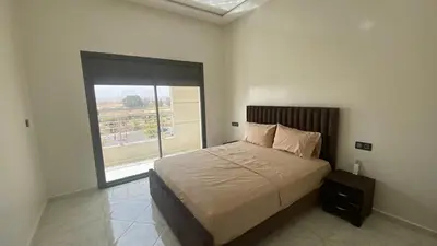 a bedroom with a bed and a large window at Near University Balcony in Fès