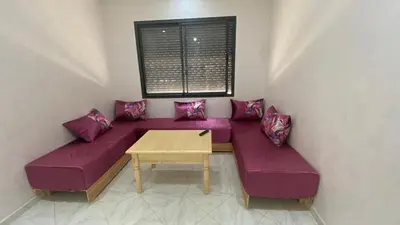 a purple couch with pillows and a table in a room at Near University Balcony in Fès