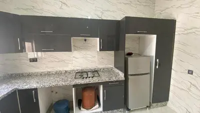 a kitchen with gray cabinets and a white refrigerator at Near University Balcony in Fès