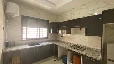 a kitchen with black cabinets and a sink and a window at Near University Balcony in Fès