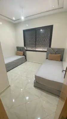 a bedroom with two beds and a tiled floor at Near University Balcony in Fès