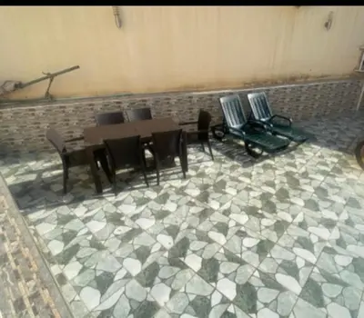 a room with chairs and tables and a brick wall at Villa avec piscine-Meknès in Oulad Akkou