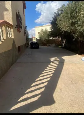 a shadow of a building and a car on a street at Villa avec piscine-Meknès in Oulad Akkou