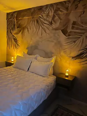 a bedroom with a bed with a painting on the wall at cosy studio au coeur de casablanca in Oulad Akkou