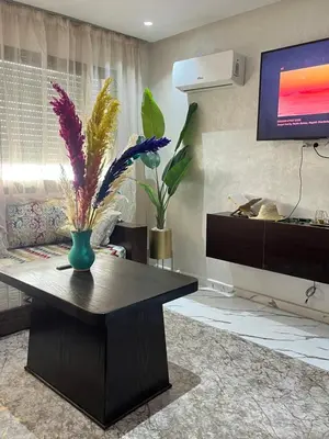 a living room with a table and a tv at cosy studio au coeur de casablanca in Oulad Akkou