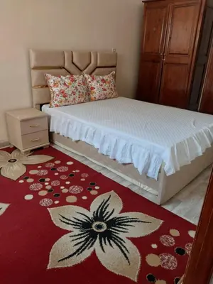 a bedroom with a bed with a flower rug at Appartement massira in Beni Mellal