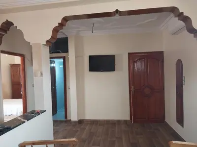 a room with a wooden door and a tv on the wall at Appartement massira in Beni Mellal