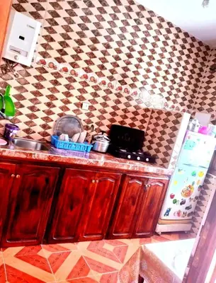 a kitchen with a sink and a checkered wall at Dar Hayoun in Oulad Akkou
