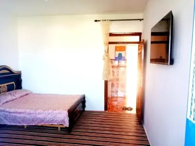 a bedroom with a bed and a door to a hallway at Dar Hayoun in Oulad Akkou