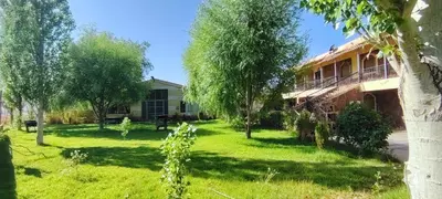 a house in the middle of a yard with trees at La ferme d'hôtes des lacs in Sefrou