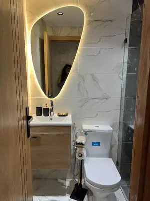 a bathroom with a toilet and a sink and a mirror at Very nice modern air-conditioned apartment in Fez in Fès