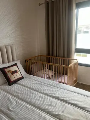 a bedroom with a crib with a pillow on a bed at Very nice modern air-conditioned apartment in Fez in Fès