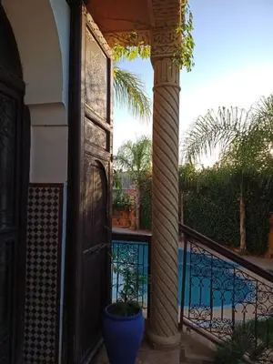 a porch with a plant in a pot on a balcony at Les Jardins de Ryad Bahia in Meknès
