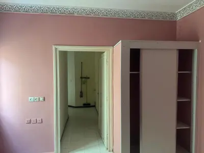 a hallway with pink walls and an open door at الامان والهدوء in Khemisset