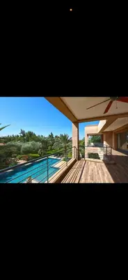 a view of a house with a pool and an umbrella at Villa Marrakech in Oulad Akkou