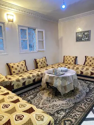 a room with two beds and a table in it at Dar dyafa in Fès