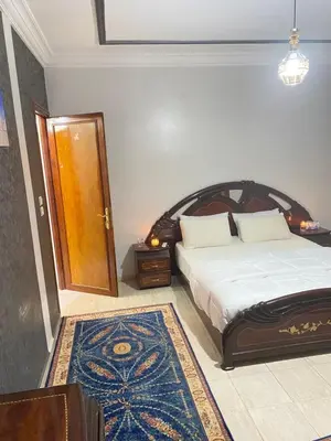 a bedroom with a bed and a door and a rug at Appartement de Luxe Fes Centre Ville in Fès