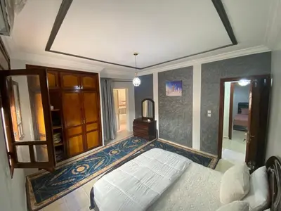 a bedroom with a white bed and a mirror at Appartement de Luxe Fes Centre Ville in Fès