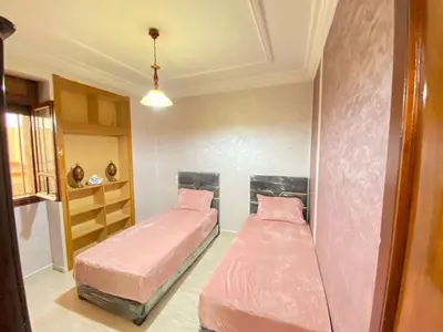 two beds in a room with pink sheets at Appartement de Luxe Fes Centre Ville in Fès