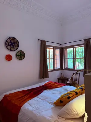 a bedroom with a bed in a room with windows at 3A Retreat Lodge in Ourika