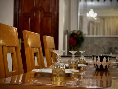 a dining room table with plates and glasses on it at Spacious 140m Family Flat with air conditioner in Fès