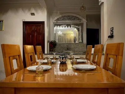a dining room table with chairs and a wooden tableablish at Spacious 140m Family Flat with air conditioner in Fès