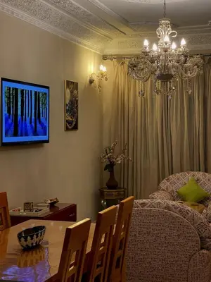 a dining room with a dining table and a chandelier at Spacious 140m Family Flat with air conditioner in Fès