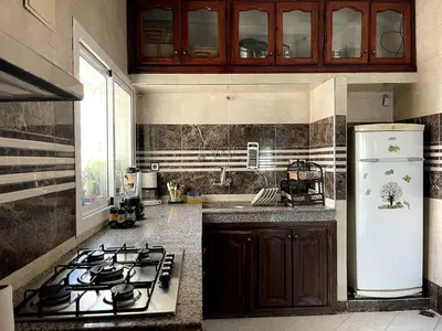 a kitchen with a stove and a white refrigerator at Spacious 140m Family Flat with air conditioner in Fès