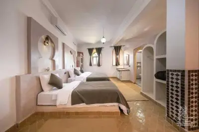 a large white bedroom with a large bed in it at Hotel Dar Sahara in Merzouga