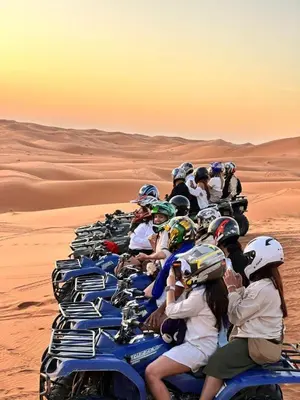 a group of people riding motorcycles in the desert at Hotel Dar Sahara in Merzouga