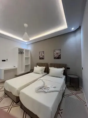 two beds in a room with white sheets at Studio lumineux avec terrasse in Er Rachidia
