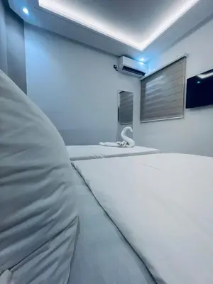 a room with two white beds and a window at Studio lumineux avec terrasse in Er Rachidia