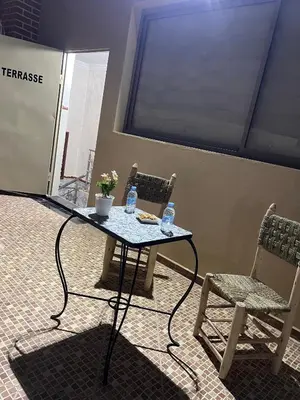 a table and two chairs with water bottles on it at Studio lumineux avec terrasse in Er Rachidia