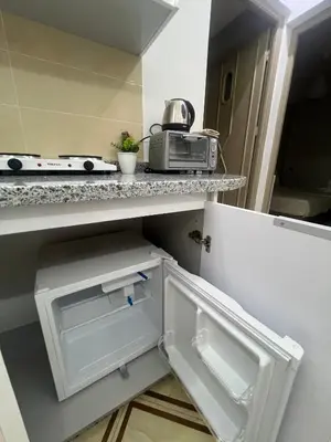 a small kitchen with a white refrigerator and a microwave at Studio lumineux avec terrasse in Er Rachidia