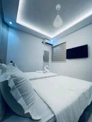 a bedroom with a large white bed with a blue wall at Studio lumineux avec terrasse in Er Rachidia