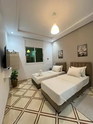 a room with two beds and a television in it at Charment studio avec terrasse in Er Rachidia