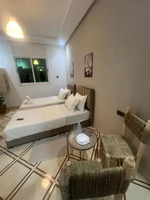 a bedroom with a bed and a table and chairs at Charment studio avec terrasse in Er Rachidia
