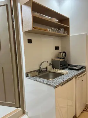 a small kitchen with a sink and a microwave at Charment studio avec terrasse in Er Rachidia